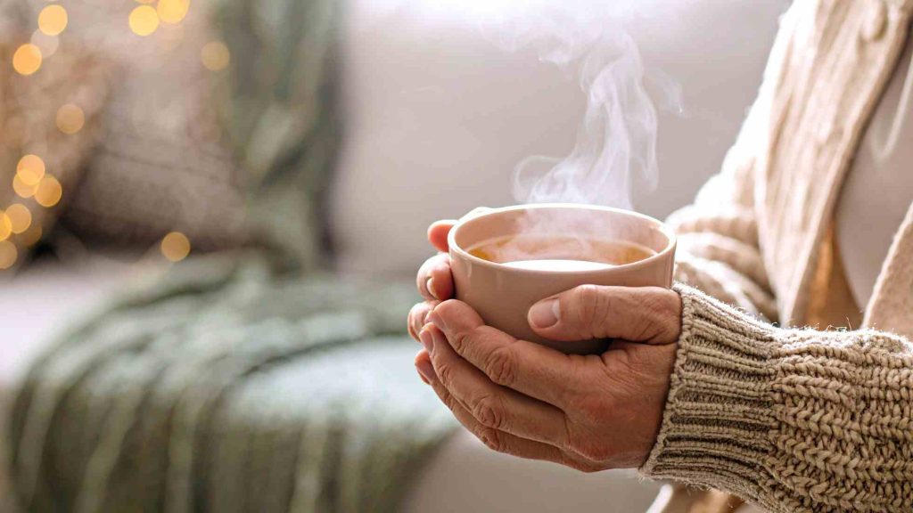 सर्दियों में गुनगुना पानी पीकर इम्यूनिटी बढ़ाते हुए व्यक्ति